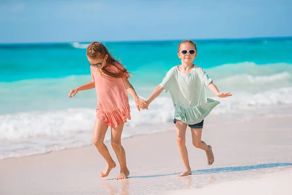 Schattige kleine meisjes veel plezier samen op witte tropisch strand — Stockfoto