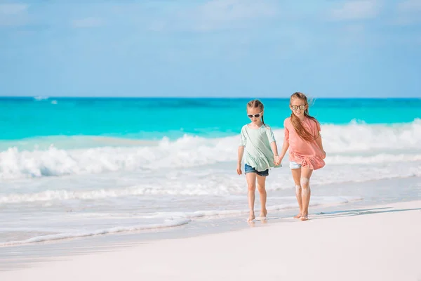 Le bambine si divertono sulla spiaggia tropicale giocando insieme in acque poco profonde — Foto Stock