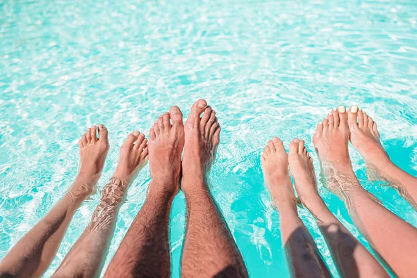 Primo piano di quattro persone gambe a bordo piscina — Foto Stock