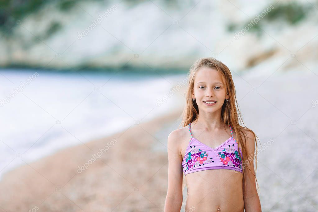 Happy little girl walking at beach during caribbean vacation