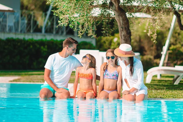 Young family with two kids enjoy summer vacation in outdoor pool — Stock Photo, Image