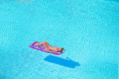 Büyük yüzme havuzunda bikini hava şilte genç kadın
