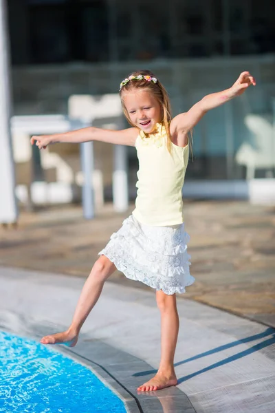 Μικρό κορίτσι Διασκεδάζοντας με έναν παφλασμό κοντά στην πισίνα — Φωτογραφία Αρχείου