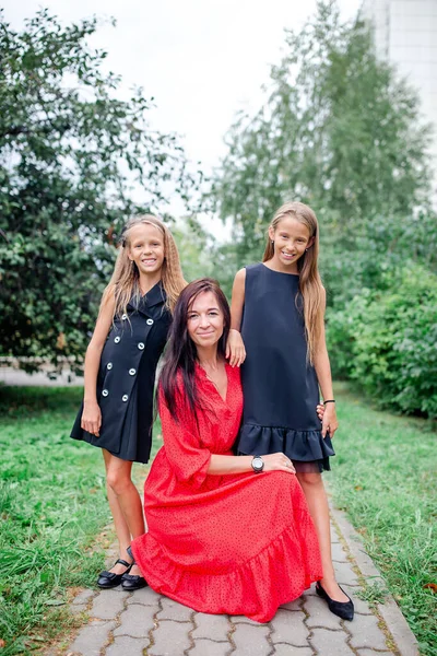 Mãe e suas filhas para a escola. Meninas adoráveis sentindo-se muito animado sobre voltar para a escola — Fotografia de Stock