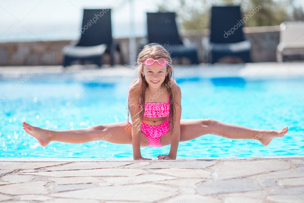 Little happy girl in outdoor swimming pool enjoy her vacation