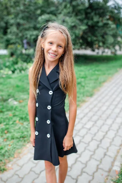 Felice scuola ragazza in posa a scuola ourdoors — Foto Stock