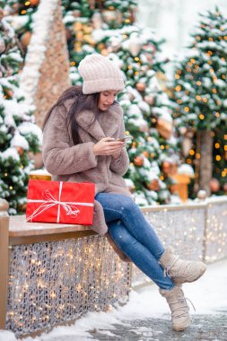 Mutlu kız yılbaşı için karların içinde köknar ağacı dalının yanında.