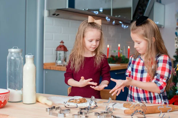 Adorables niñas felices horneando galletas de jengibre de Navidad en Nochebuena —  Fotos de Stock