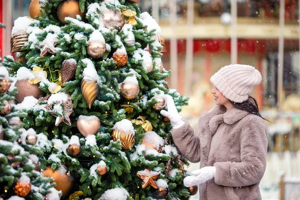 Lycklig flicka nära granen gren i snö för nytt år. — Stockfoto