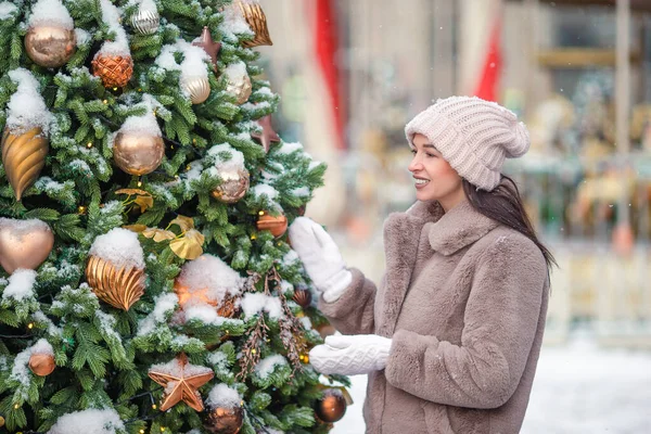 Lycklig flicka nära granen gren i snö för nytt år. — Stockfoto