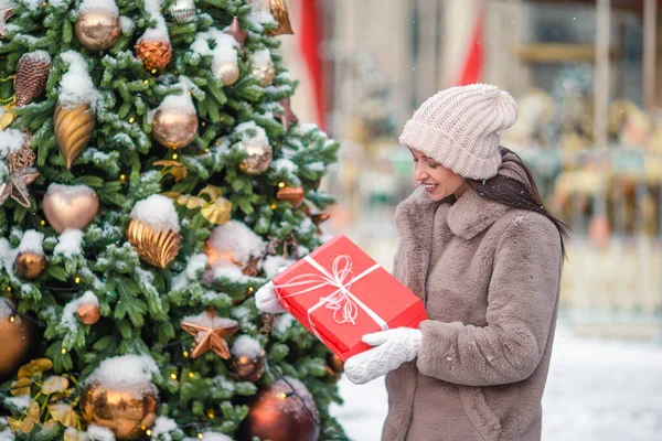 La muchacha feliz cerca de la rama del abeto en la nieve para un nuevo año. —  Fotos de Stock