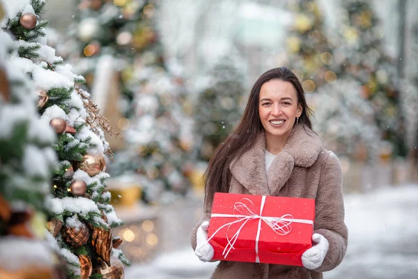 La muchacha feliz cerca de la rama del abeto en la nieve para un nuevo año. —  Fotos de Stock