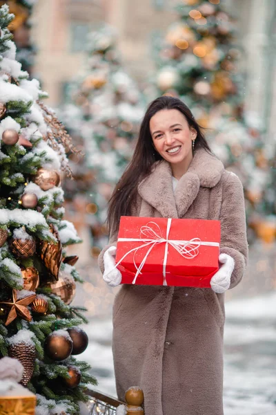 Glückliches Mädchen in der Nähe von Tannenzweig im Schnee für Neujahr. — Stockfoto