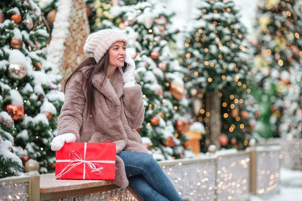 Happy girl near fir-tree branch in snow for New year. — Stock fotografie