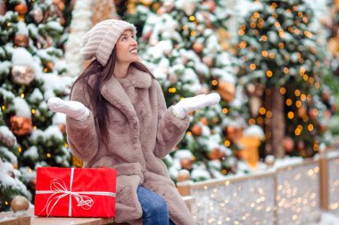 Mutlu kız yılbaşı için karların içinde köknar ağacı dalının yanında.