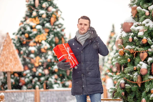 El hombre feliz cerca de la rama del abeto en la nieve para un nuevo año . —  Fotos de Stock