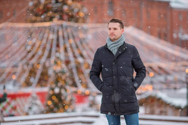 Glücklicher Mann in der Nähe von Tannenzweig im Schnee für Neujahr. — Stockfoto