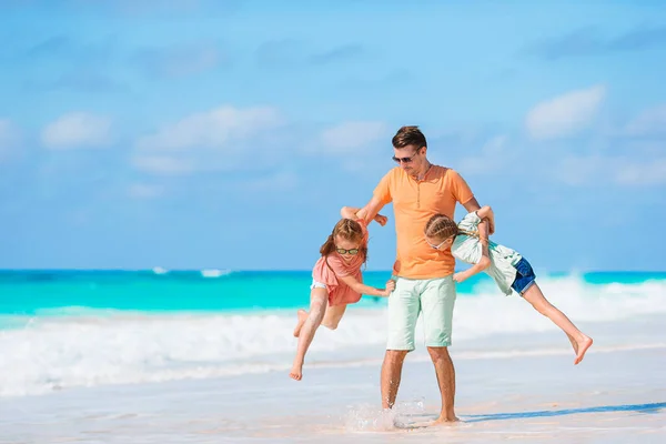Vader en kinderen genieten van strandvakantie — Stockfoto