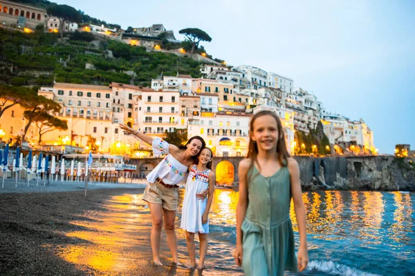 Schattig klein meisje bij zonsondergang in Amalfi stad in Italië — Stockfoto