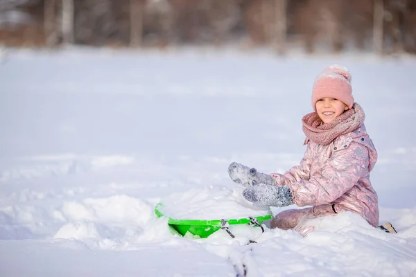 Adorable niña feliz trineo en invierno día nevado . — Foto de Stock