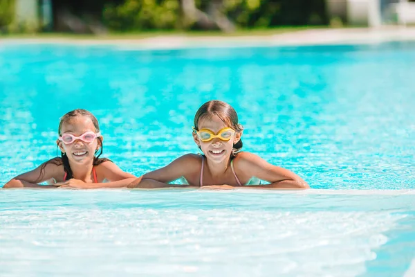 Adorables petites filles jouant dans la piscine extérieure en vacances — Photo