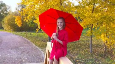 Mutlu kız kırmızı şemsiye altında gülüyor