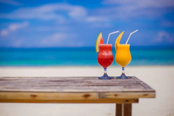 Fresh watermelon and mango cocktails on woodem table background of stunning turquoise sea — Stock Photo, Image