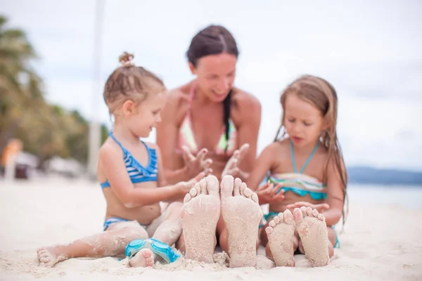 Close-up of the feet of mother and two daughters on the white sandy beach — Stock Photo, Image