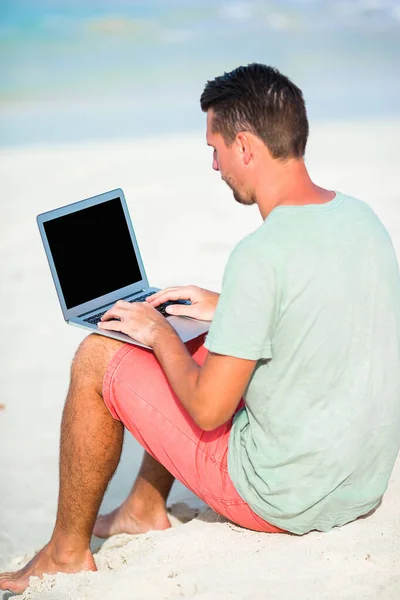 Młody człowiek z tabletem podczas tropikalnych wakacji na plaży — Zdjęcie stockowe