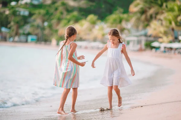 Маленькі дівчата розважаються, насолоджуючись відпочинком на тропічному пляжі — стокове фото