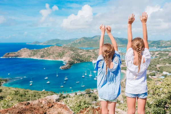 Adorable little kids enjoying the view of picturesque English Harbour at Antigua in caribbean sea