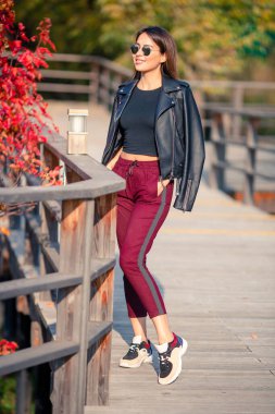 Sonbahar konsepti: Sonbahar parkında sonbahar yaprakları altında kahve içen güzel bir kadın.