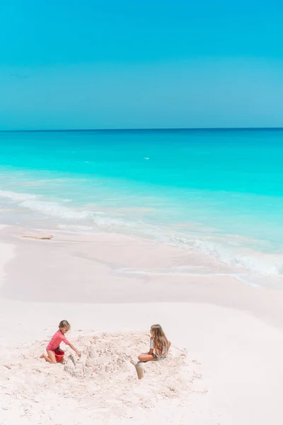 Adorable little kids play with sand on the white beach — Stock Photo, Image