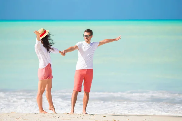 Jong koppel lopen op tropisch strand met wit zand en turquoise oceaanwater op Antigua eiland in Caribisch gebied — Stockfoto