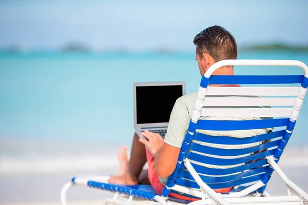 Anak muda dengan komputer tablet selama liburan pantai tropis — Stok Foto