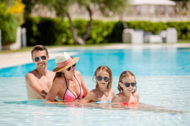 Yüzme havuzunda dört mutlu aile