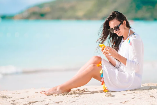 Mladá žena s chytrým telefonem během tropické dovolené na pláži. — Stock fotografie
