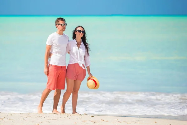 Junges Paar am tropischen Strand mit weißem Sand und türkisfarbenem Meerwasser auf der Insel Antigua in der Karibik — Stockfoto