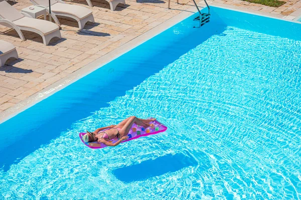 Młoda kobieta w bikini powietrza materac w dużym basenie — Zdjęcie stockowe