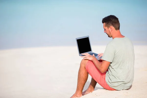 Młody człowiek z tabletem podczas tropikalnych wakacji na plaży — Zdjęcie stockowe