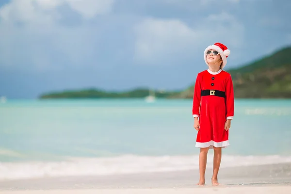 Nuttet lille pige i Santa hat på tropisk strand - Stock-foto
