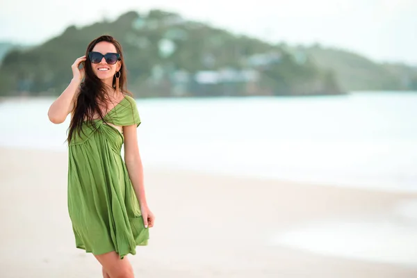 Junge Modefrau in grünem Kleid am Strand — Stockfoto