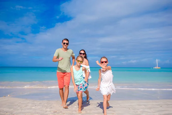 Família feliz na praia durante as férias de verão — Fotografia de Stock