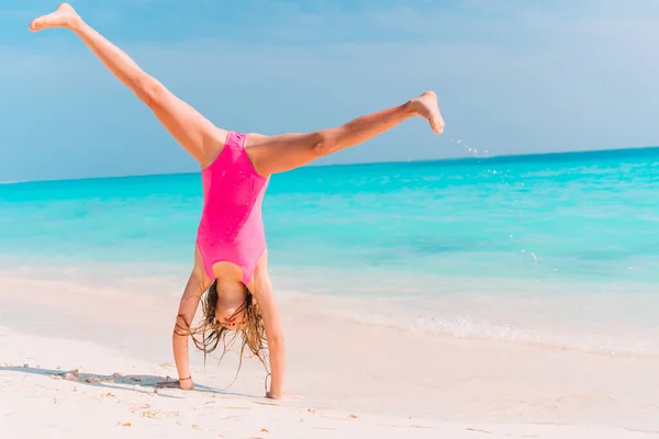 Schattig actief klein meisje aan het strand tijdens de zomervakantie — Stockfoto
