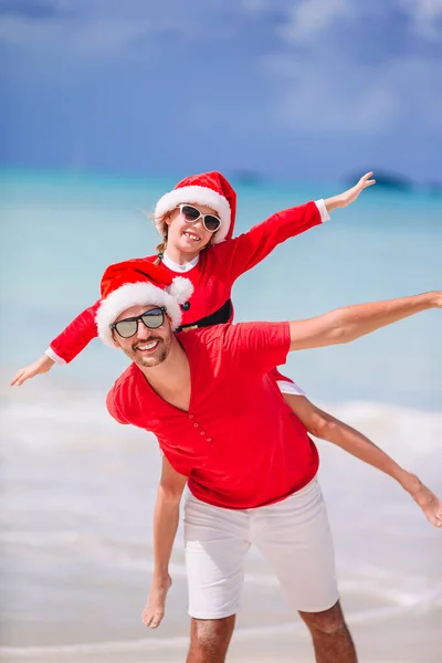 Otec a dcera v santa hat bavit se na tropické pláži — Stock fotografie