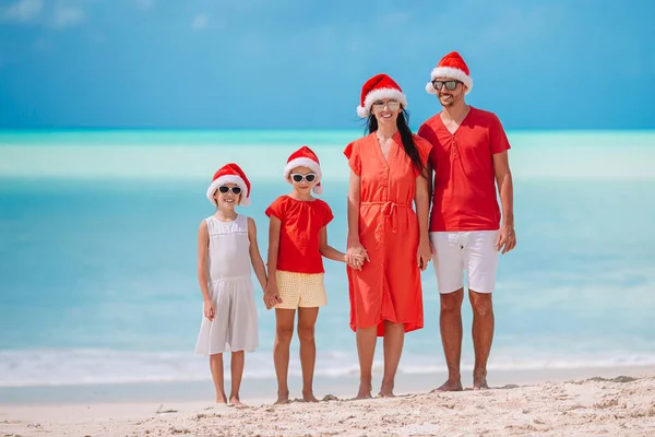 Glückliche Familie mit zwei Kindern in Santa Hat im Sommerurlaub — Stockfoto