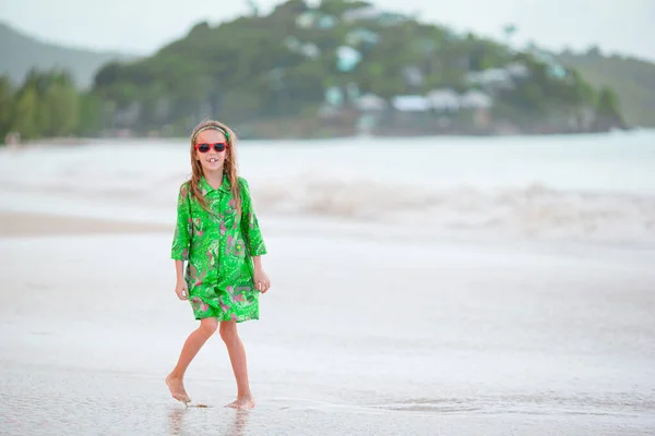 Entzückendes kleines Mädchen mit großem roten Hut am Strand — Stockfoto