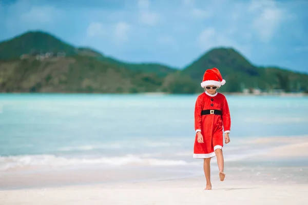 Rozkošná holčička v santa hat na tropické pláži — Stock fotografie