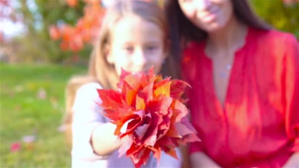Маленькая девочка с мамой на открытом воздухе в парке в осенний день — стоковое видео