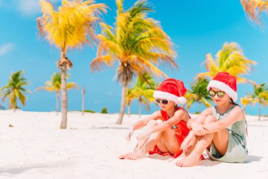 Noel Baba şapkaları birlikte eğleniyor beach Noel tatil sırasında küçük sevimli kız